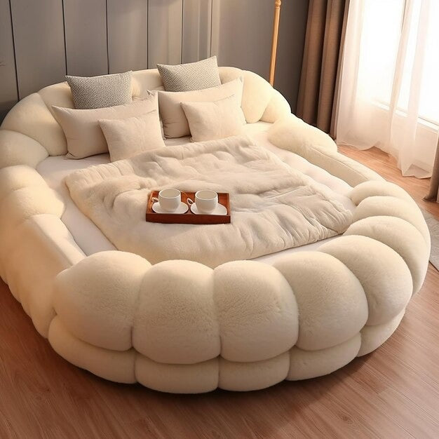 Round boucle sofa bed with plush texture in creamy white, featuring pillows and a throw.