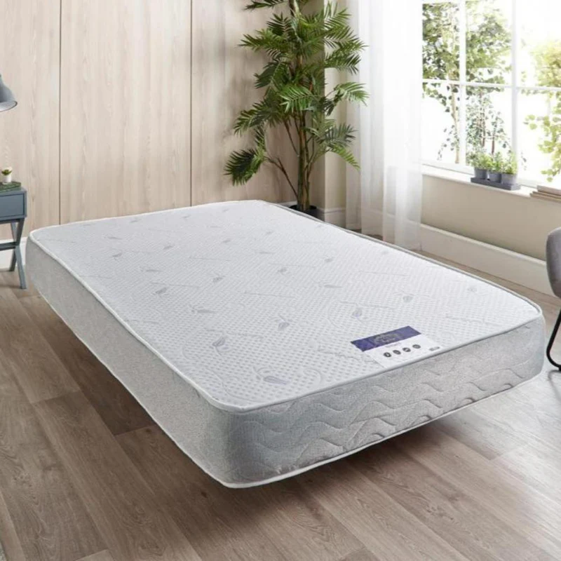 White diamond mattress with gray sides in a bright, modern bedroom.