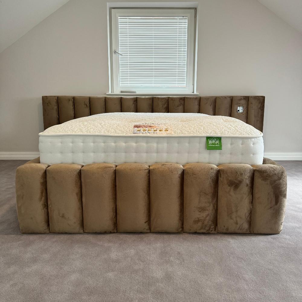 Double bed with mattress, positioned in front of a window with white blinds.