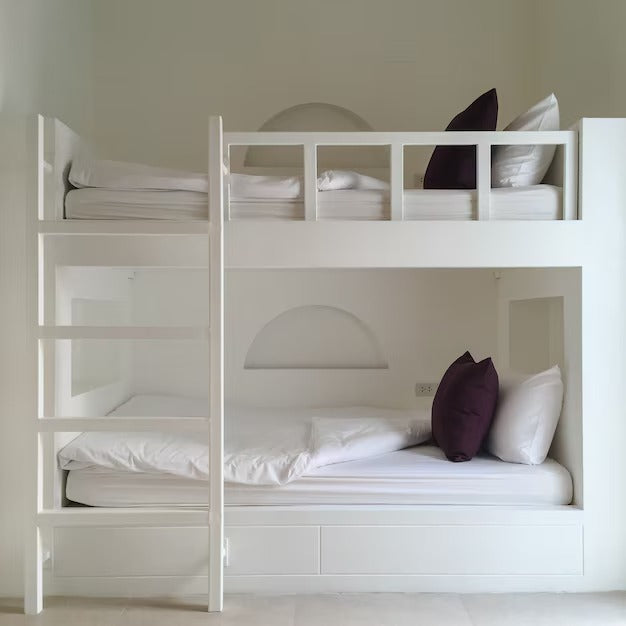 White double loft bunk bed with dark purple pillows.