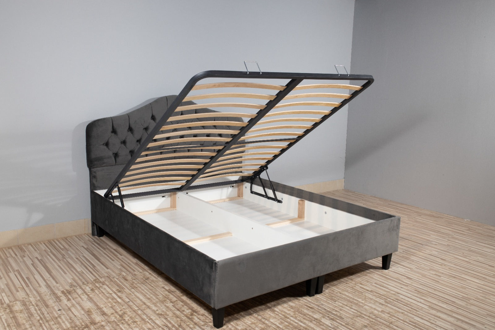 The image features a wooden bed frame, specifically the Dusk Ottoman Bed. It showcases a stylish design that complements the indoor setting, with elements  its aesthetic.