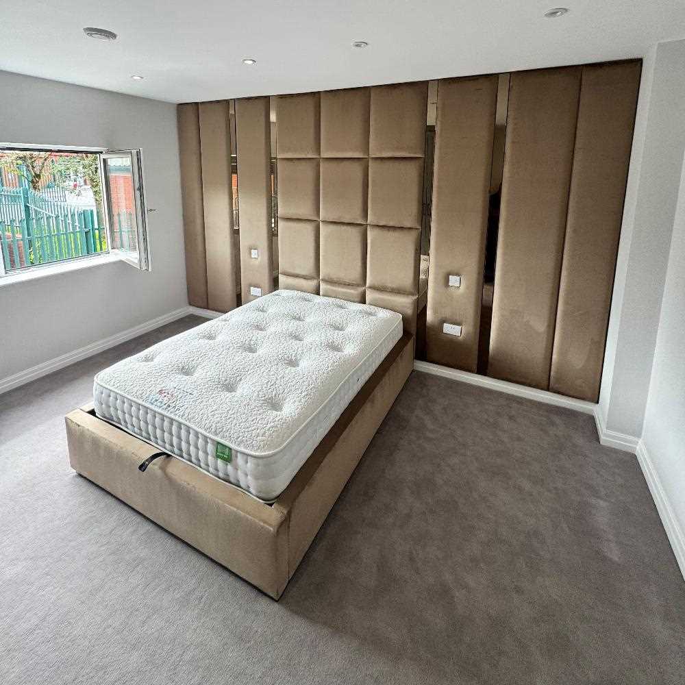 Bedroom with a wall-mounted headboard and matching bed frame.