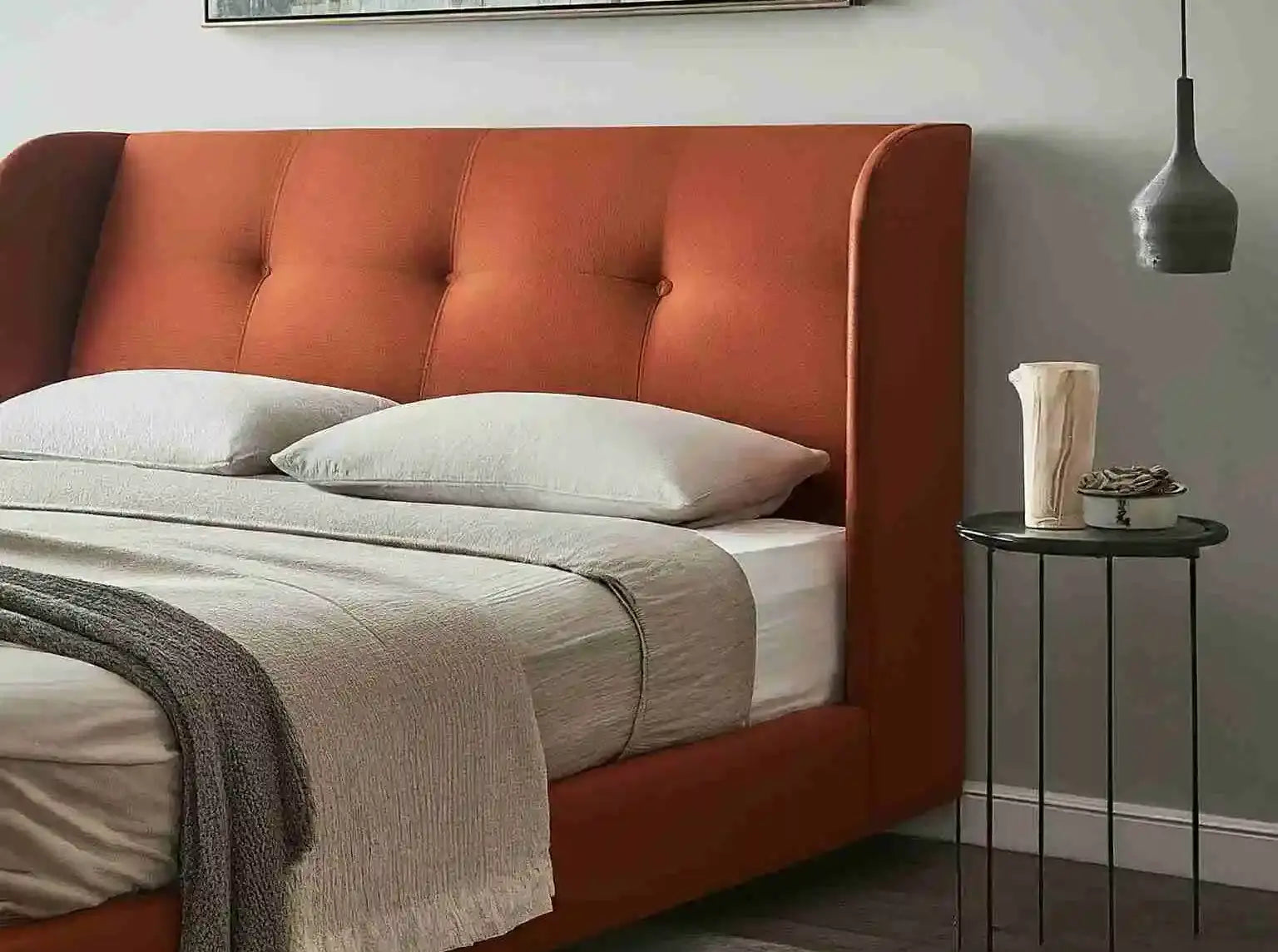 A cozy upholstered wingback bed in a bedroom with warm, natural light.