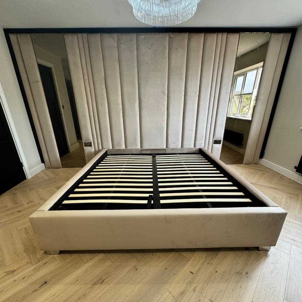 A straight-on view highlighting the bed's symmetrical design. This perspective clearly shows the black and white slat system, vertical channel tufting detail, and the full expanse of the upholstered Royal wall panel Bed flanked by mirrors.