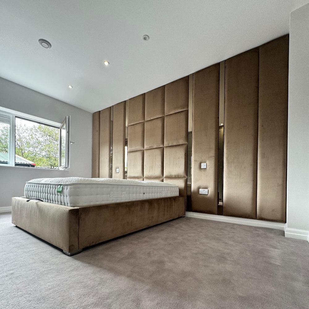 The Nexus Hybrid Wall Panel enhances this modern bedroom, featuring a brown padded headboard that blends seamlessly with the low-profile bed. Natural light from the window highlights the room's contemporary style.