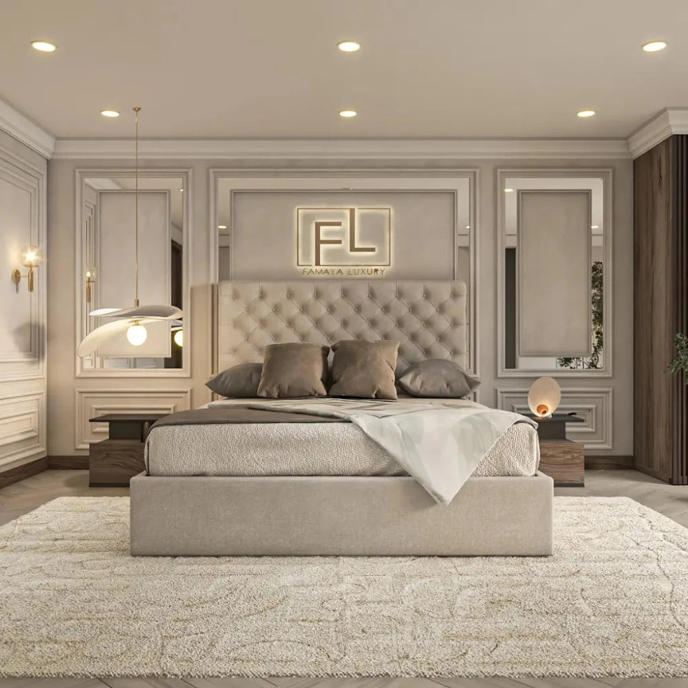 The image shows a luxurious bedroom with a plush, tufted bed frame in light grey fabric, topped with grey and beige bedding. The room features elegant wall paneling and soft ambient lighting, including two wall sconces and a pendant lamp. A wooden nightstand with a modern lamp completes the sophisticated look—perfectly highlighting The Valencia Bed Frame.